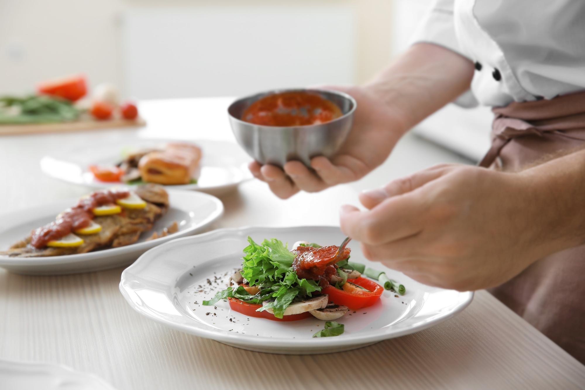 Chef in a quiet kitchen arranging a plate